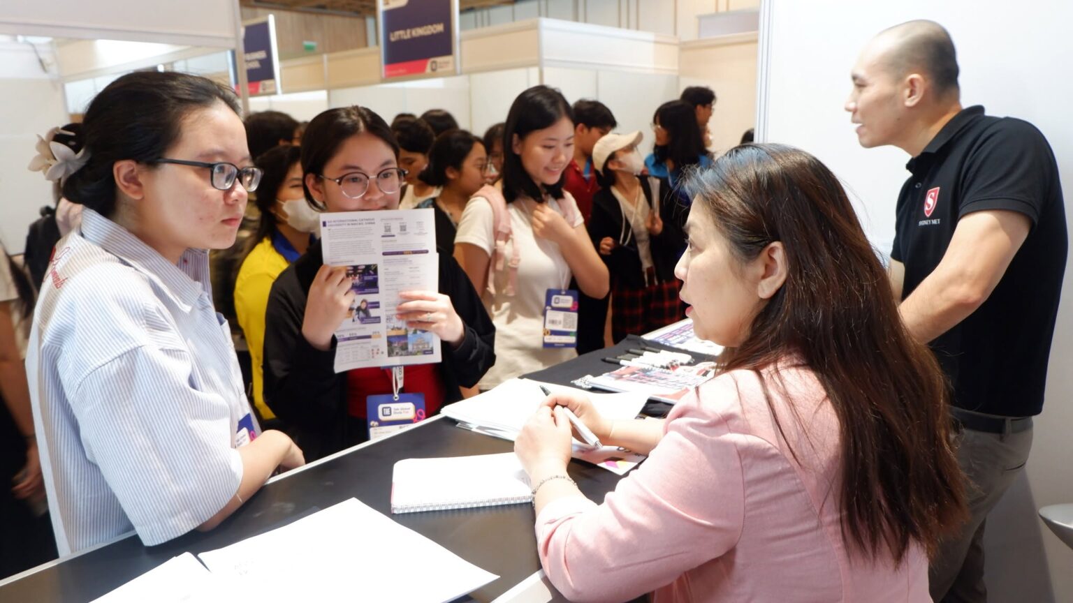 Consultant advising students at an education fair booth
