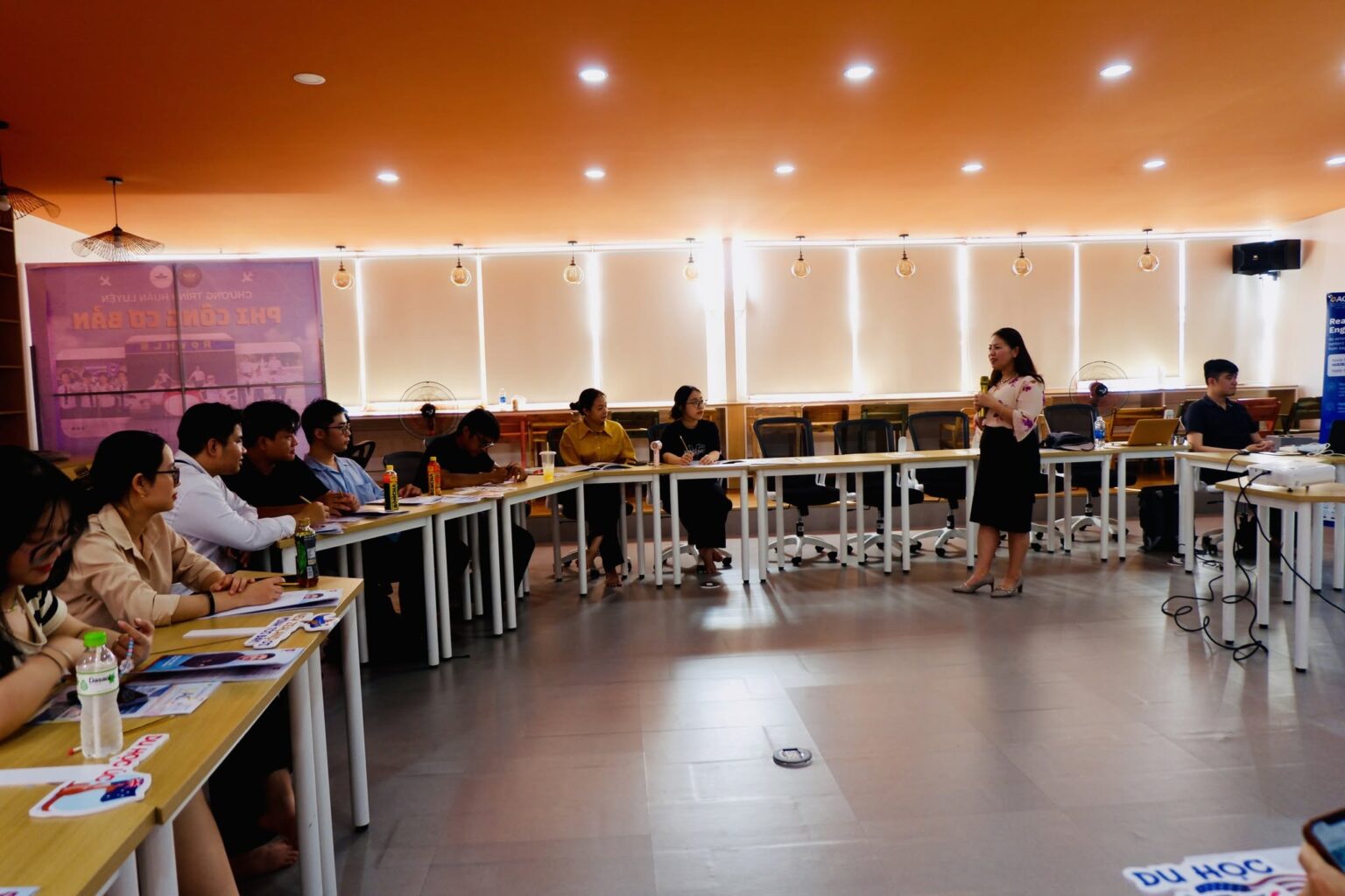 Presenter leading a training workshop with a seated group